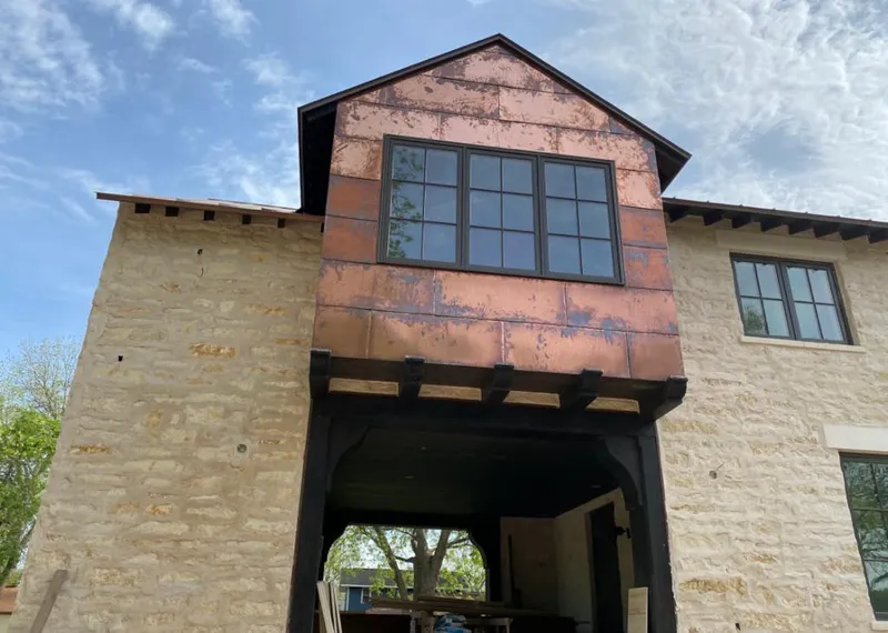 Copper metal panel facade on a stone building for Roof Repair in Sugar Land